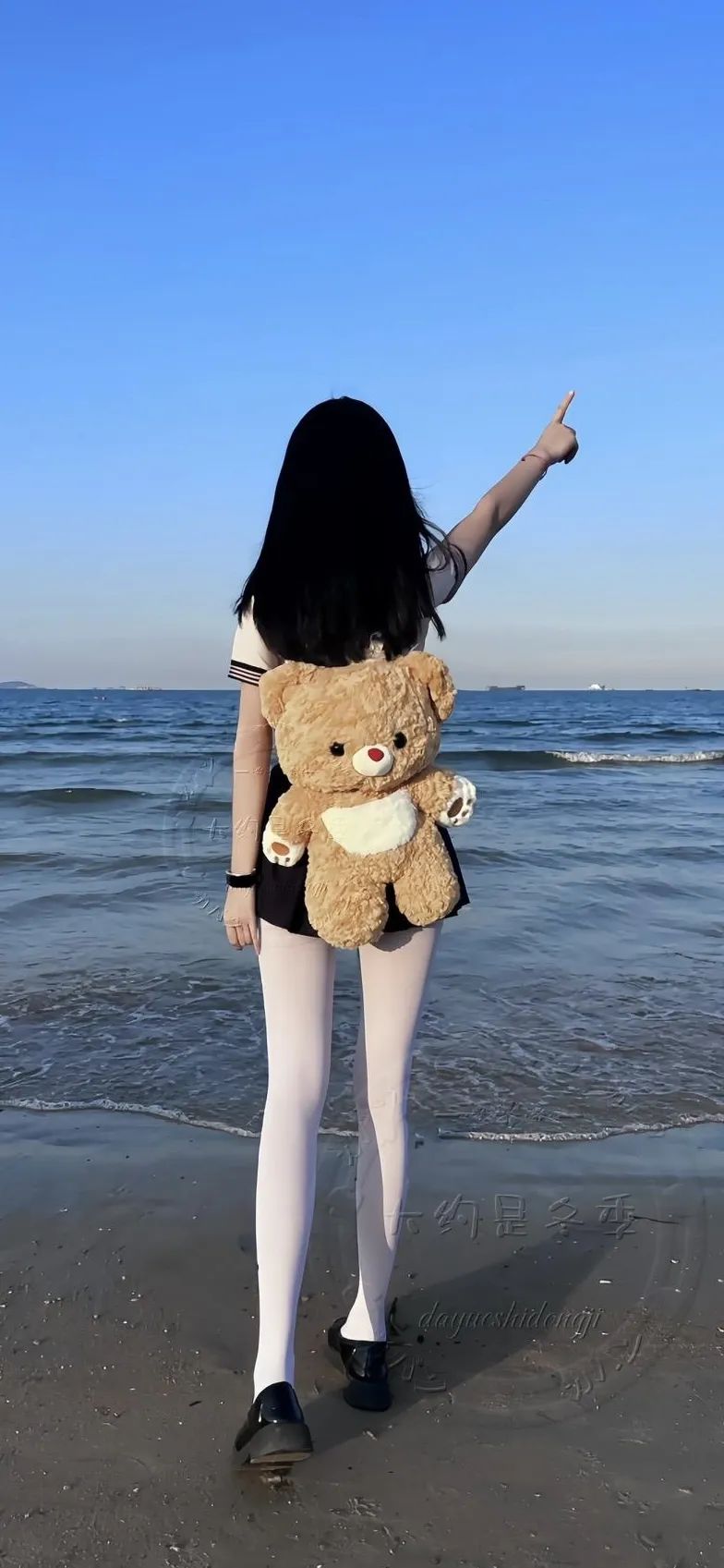 白丝少女背影指着海边手机壁纸