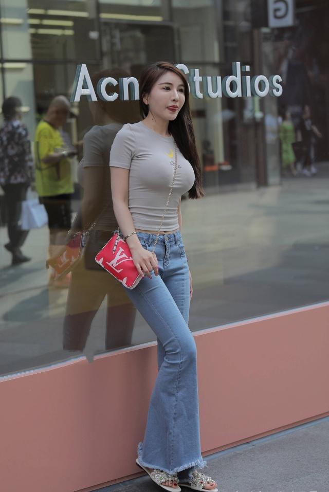 上窄下宽的喇叭牛仔裤,配上修身的紧身装,好身材明显呈现